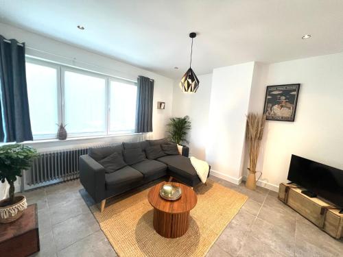 a living room with a couch and a table at Maison proche de Pairi Daiza in Soignies