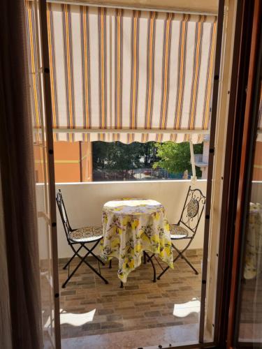 a table and chairs on a balcony with a window at Relax Rosolina Mare in Rosolina Mare