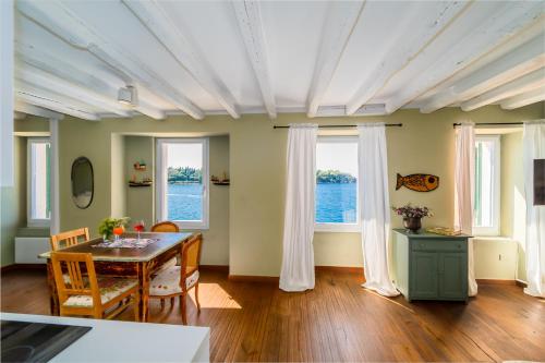 a dining room with a table and two windows at Mediterraneo Seaview Apartments in Rovinj