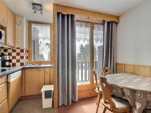 une petite cuisine avec une table et une fenêtre dans l'établissement Bel appartement rénové 2 pièces, balcon, proche pistes et commerces - FR-1-455-148, à Aime La Plagne