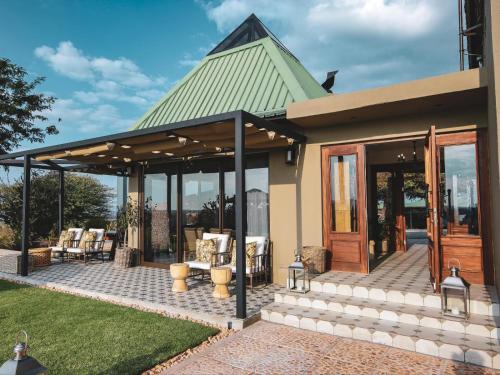 a house with a screened in porch with a patio at Otjiwa Mountain Lodge in Otjiwarongo