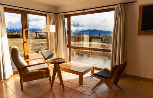 a living room with a table and chairs and a large window at Blue Aparts Dina Huapi Bariloche in Dina Huapi