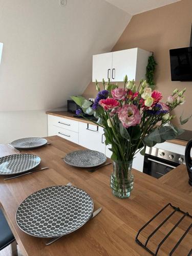 une table avec des assiettes et un vase de fleurs dans l'établissement T2 Centre ville proche gare - Tramway au pied, à Nantes