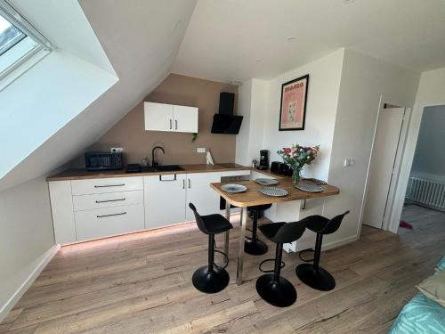 une cuisine avec une table et des tabourets dans une pièce dans l'établissement T2 Centre ville proche gare - Tramway au pied, à Nantes