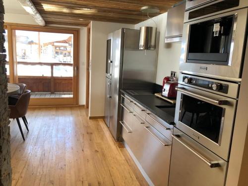 d'une cuisine équipée d'appareils en acier inoxydable et d'une fenêtre. dans l'établissement Luxe au Cœur de la Station, à Huez