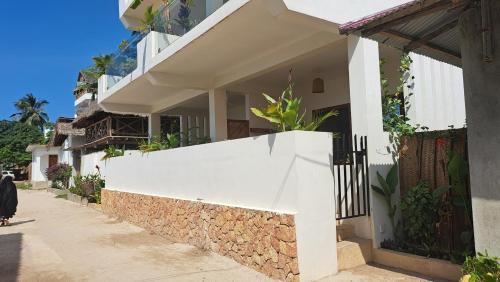a white wall on the side of a house at Aluna Beach Apartments in Nungwi