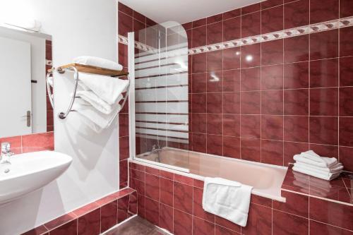 a bathroom with a tub and a sink at Grand Hôtel De Paris in Paris