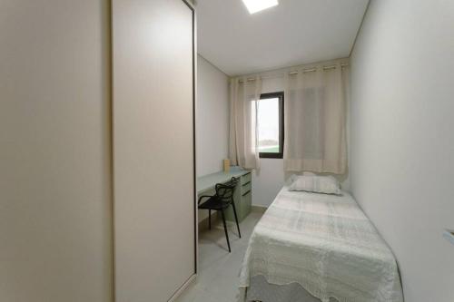 a bedroom with a mirror and a bed and a desk at Lindo Moderno e Central TV102 in Maringá