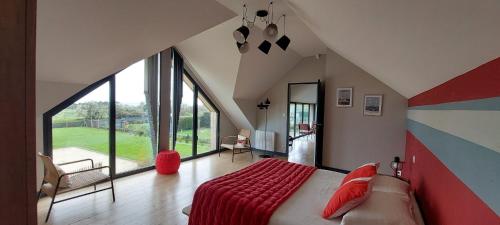 a bedroom with a large bed and a large window at Les Grands Gîtes de Cancale, gîtes de charme avec jacuzzi in La Coudre