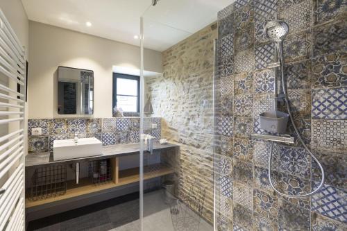 a bathroom with a sink and a shower at Les Grands Gîtes de Cancale, gîtes de charme avec jacuzzi in La Coudre