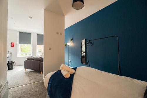 a bedroom with a blue accent wall and a bed at Legion House Apartment One Middlesbrough in Middlesbrough