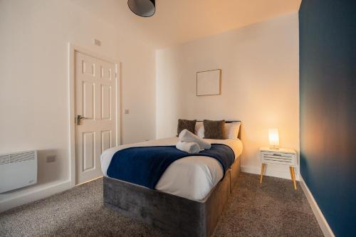 a bedroom with a bed and a night stand with a lamp at Legion House Apartment One Middlesbrough in Middlesbrough