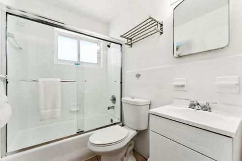 a white bathroom with a toilet and a sink at Catalina by the beach 2 in Pompano Beach