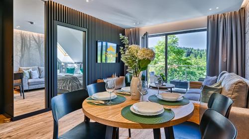 a dining room with a table and chairs at Apartamenty z basenem i saunami STONE HILL RESORT II VIP Centrum by Royal Aparts in Szklarska Poręba