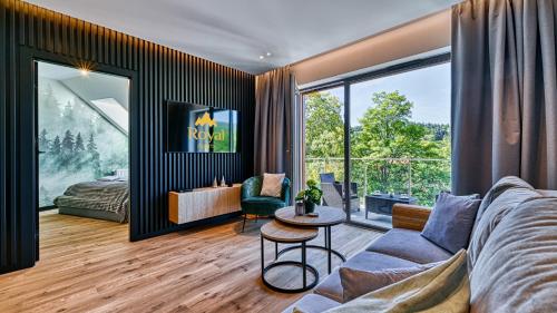 a living room with a couch and a table at Apartamenty z basenem i saunami STONE HILL RESORT II VIP Centrum by Royal Aparts in Szklarska Poręba