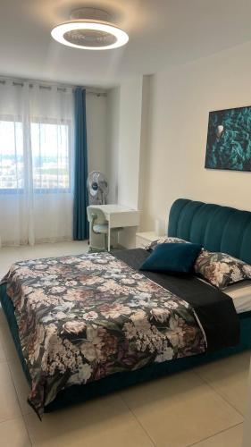 a bedroom with a large bed with a floral blanket at Cozy Ocean view 1 BDR APT, Club Paraiso in Playa Paraiso