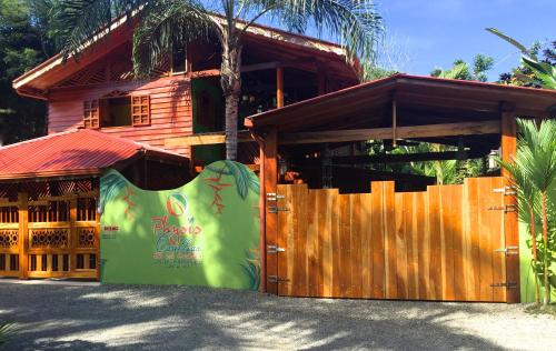 a wooden building with a fence in front of it at Physis Caribbean Bed & Breakfast in Puerto Viejo