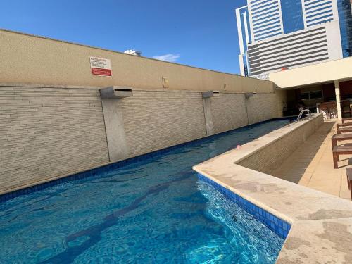 a swimming pool in front of a building at Apartamento 2Q Próximo ao Albert Einstein EC1003 in Goiânia