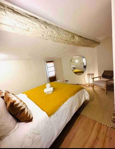 une chambre avec un grand lit avec une couverture jaune dans l'établissement Appartement hyper centre Aix, à Aix-en-Provence