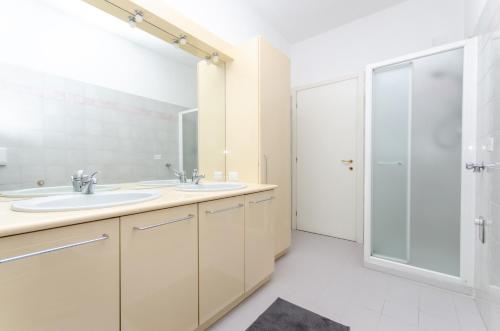 une salle de bain avec deux lavabos et une douche dans l'établissement Yellow Room, à Milan