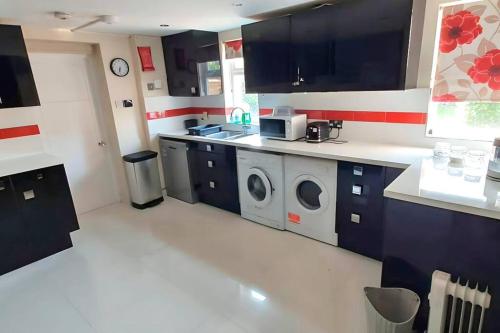 a kitchen with a washer and dryer in it at 6 Bedroom Spacious villa, Free Parking in Byfleet