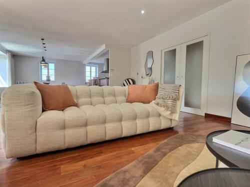 a large white couch in a living room at La maison de Vincent de Miss K in Romanèche-Thorins