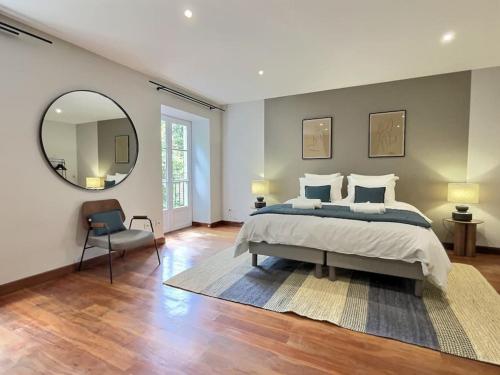 a bedroom with a large bed and a mirror at La maison de Vincent de Miss K in Romanèche-Thorins
