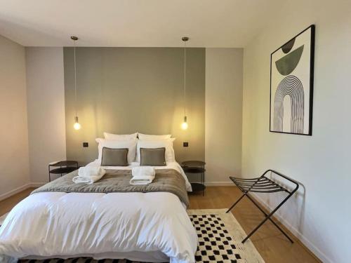 a bedroom with a large bed with white sheets at La maison de Vincent de Miss K in Romanèche-Thorins