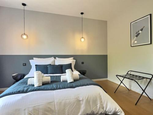 a bedroom with a large bed with three pillows at La maison de Vincent de Miss K in Romanèche-Thorins