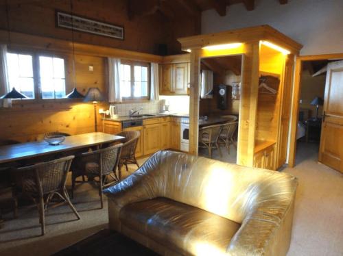 un divano in pelle in un soggiorno con cucina di South Facing Family Chalet in Saanen Village a Gstaad