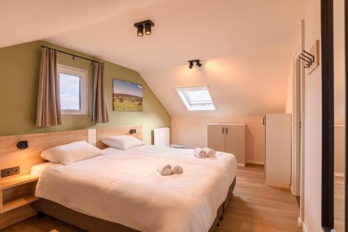 a bedroom with a large bed with two towels on it at Summio Vakantiepark Reevallis in Vijlen