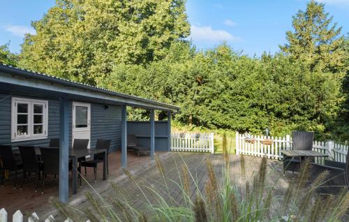 a blue tiny house with a table and a fence at 3 Bedroom Cozy Home In Nykøbing Sj in Lumsås