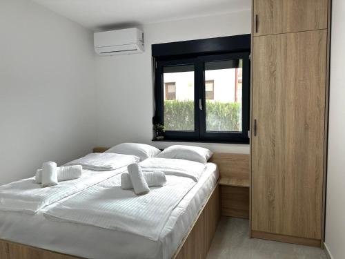 two beds in a room with a window at BLUE SKY Apartments in Sarajevo