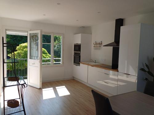 Il comprend une cuisine avec des murs blancs et du parquet. dans l'établissement Maison Mela, à Saumur