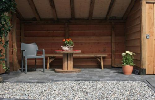a wooden patio with a table and two chairs at Herenstraat 55 in Den Hoorn