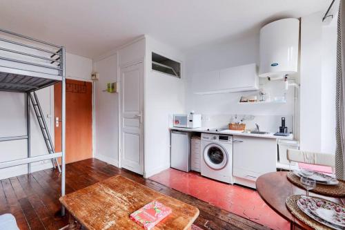 - une cuisine blanche avec un lave-linge et une table dans l'établissement Studio pour 3 - Confort Moderne, Proche Métro, à Paris