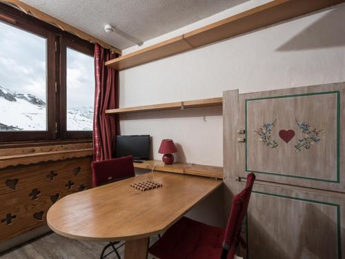 Pokój z biurkiem, stołem i oknem w obiekcie Studette confortable proche pistes et commerces - FR-1-502-453 w mieście Tignes