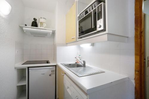 a small kitchen with a sink and a microwave at A3 209 Appart au pied des pistes in Saint-François-Longchamp