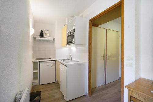 une petite cuisine avec des armoires blanches et un évier dans l'établissement A3 209 Appart au pied des pistes, à Saint-François-Longchamp