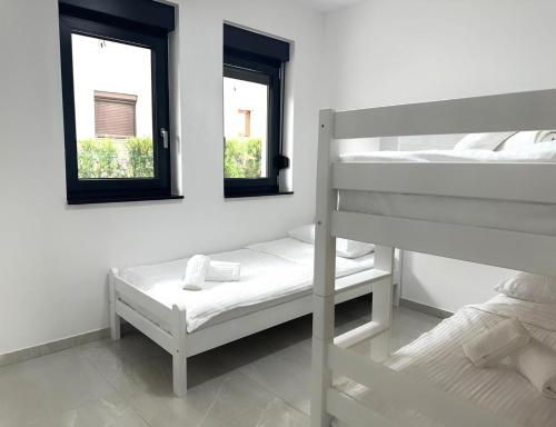 a bedroom with two bunk beds and two windows at BLUE SKY Apartments in Sarajevo