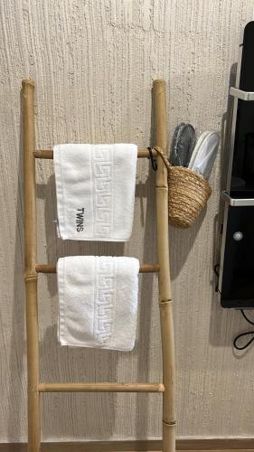 a bamboo towel rack with towels and a basket at Casa Twins - Slanic Moldova in Slănic-Moldova