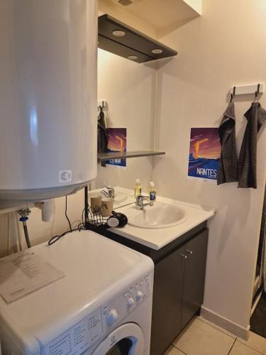 une salle de bain avec une machine à laver et un lavabo dans l'établissement Studio Déco Moderne à Nantes - Comme à la Maison, à La Contrie