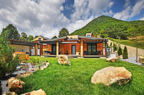 a house on a hill with a yard with rocks at Casa Twins - Slanic Moldova in Slănic-Moldova
