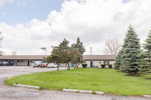 a parking lot in front of a building with trees at Detroit Studio, near Metropolitan Airport in Woodhaven