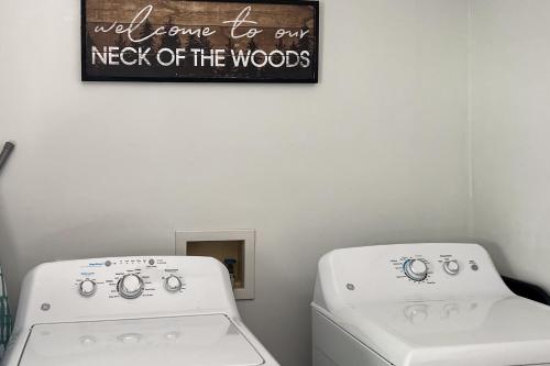 a laundry room with two washing machines and a sign on the wall at The Haggai House in Demorest