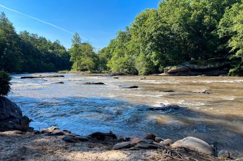 a river with rocks and trees in the background at The Haggai House in Demorest