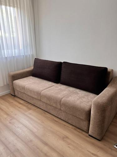 a brown couch sitting in a living room at Apartman Aldijana in Ripač