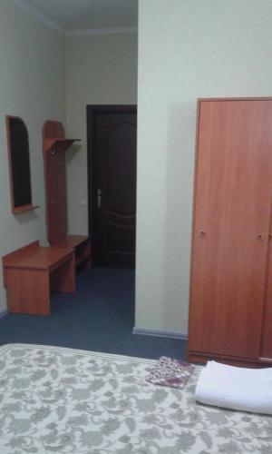 a room with a bed and a wooden cabinet and a door at Vershnyk in Cherkasy