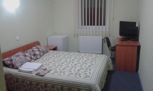 a small bedroom with a bed and a television at Vershnyk in Cherkasy