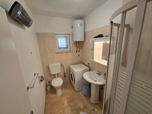 a small bathroom with a toilet and a sink at apartmani Tanja in Postira